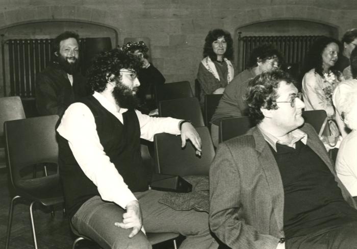 A black and white image of adults in the audience of an event
