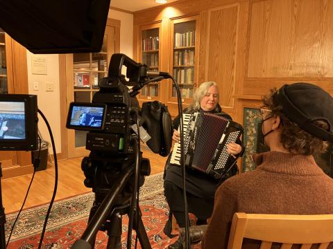 Christina Crowder playing accordion in front of camera