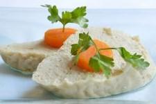 Slices of gefilte fish with carrot and parsley atop.