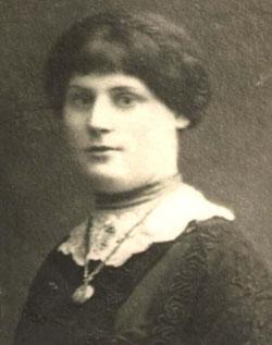 Black and white photo of a woman wearing a white lace collar and a pendant necklace