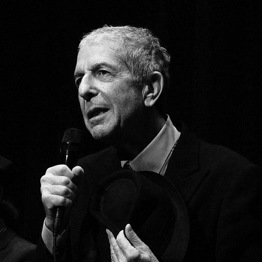 Black and white photograph of Leonard Cohen holding a microphone