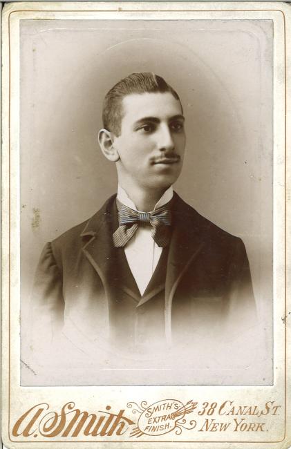Black and white photograph of a man with a moustache wearing a three piece suit and a bowtie. Text reads: A. Smith, Smith's extra finish, 38 Canal St, New York.