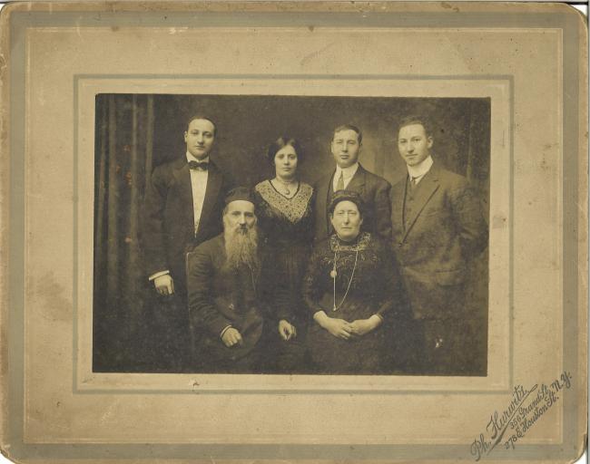 Sepia-toned family portrait, with the younger generation standing wearing modern clothing, and the older generation seated wearing traditional Jewish clothing. Text reads: Ph. Hurwitz, 365 Grand St., 278 E Houston St., N.Y.
