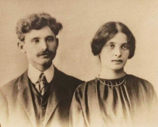 Black and white photo of a man and a woman, both with serious expressions. 