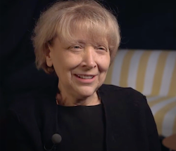 A woman with short hair sits in an interview