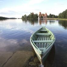 A boat on the lake at Trakai, Lithuania, with the town's castle in the background.