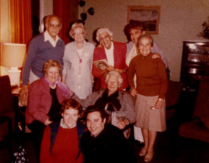 An image of nine people huddled together for a photograph