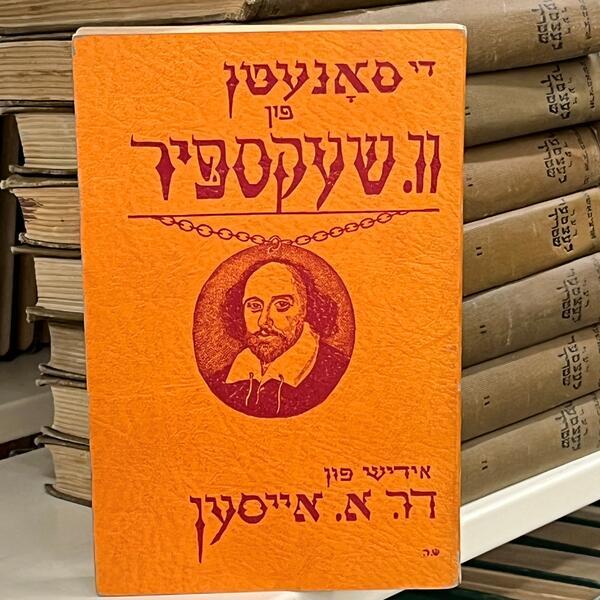Orange book cover with red Yiddish type and a red image of Shakespeare