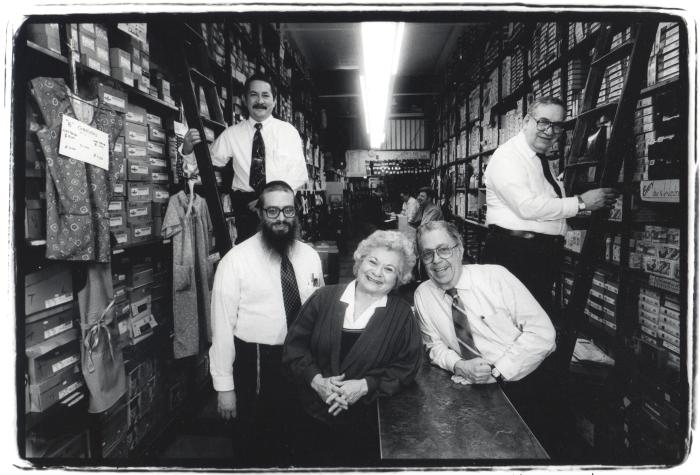 Black and white photo of four men wearing ties and white shirts and one woman