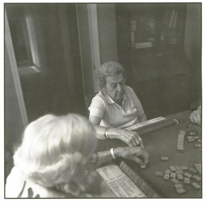 Elderly women playing mahjongg in a room. Juliet Kossman playing mahjongg at her home, Cleveland.