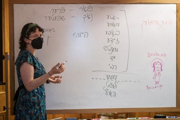Asya writing Yiddish on a whiteboard